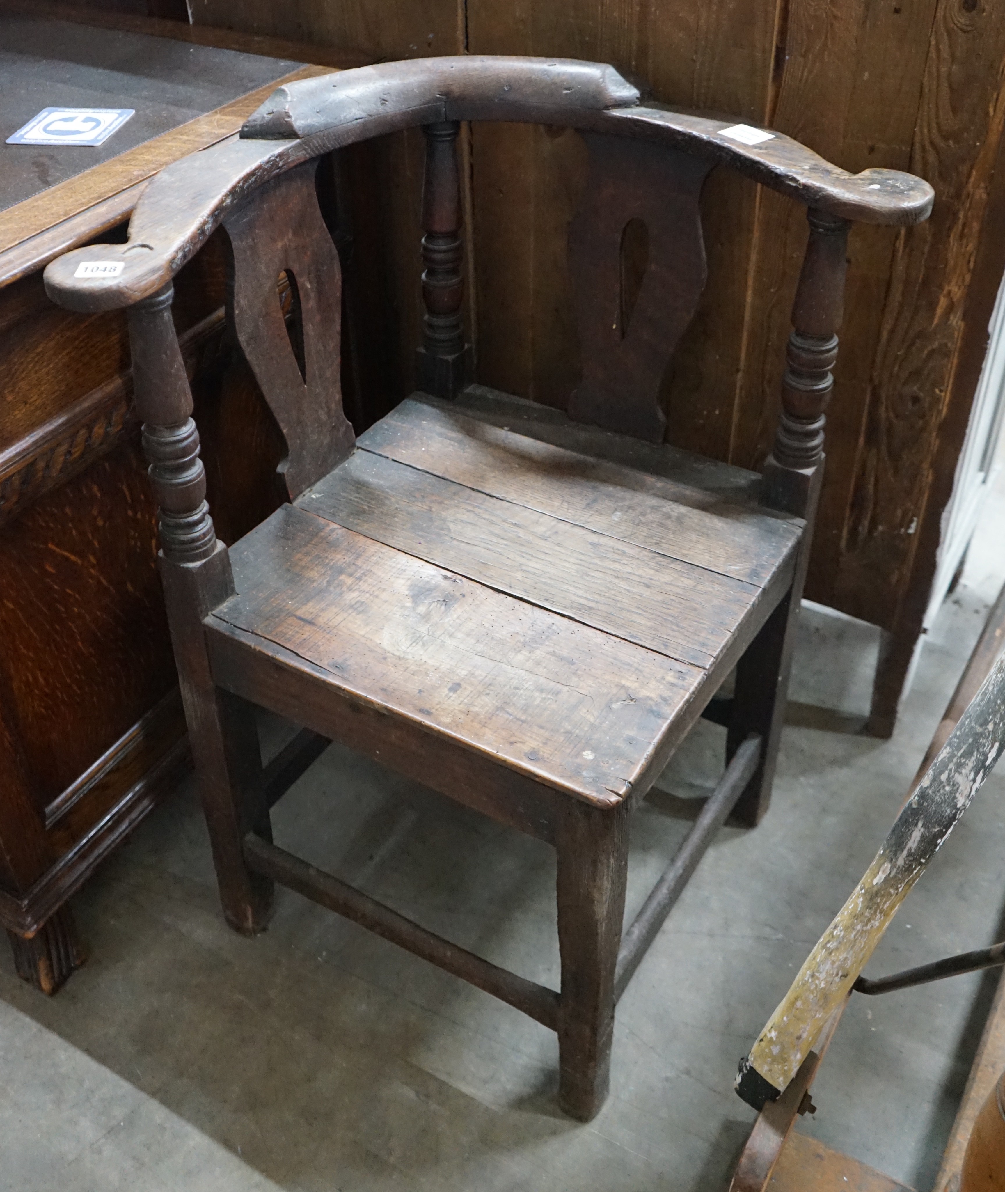A mid 18th century oak corner elbow chair